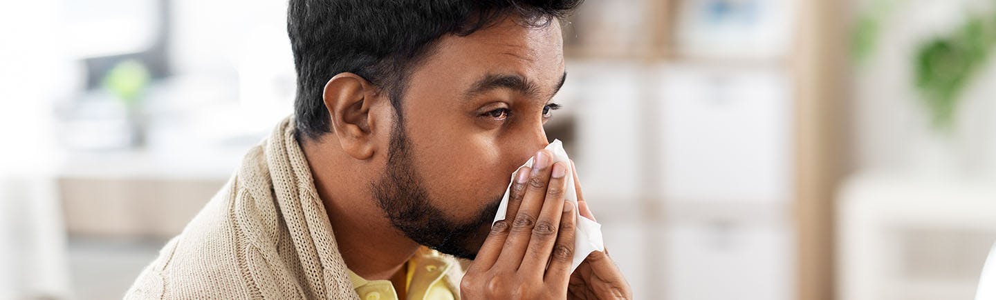 Middle-aged woman with allergy blowing her nose