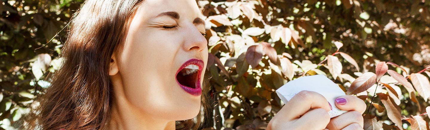 Middle-aged woman with allergy blowing her nose