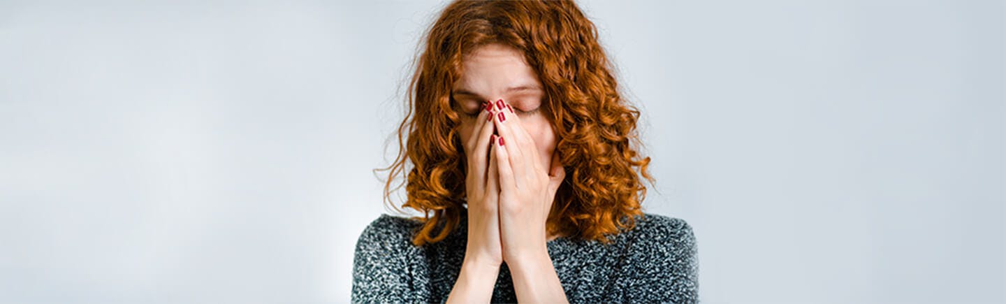 Woman sneezing due to hay fever allergy, which might be produced by pollen inhalation.