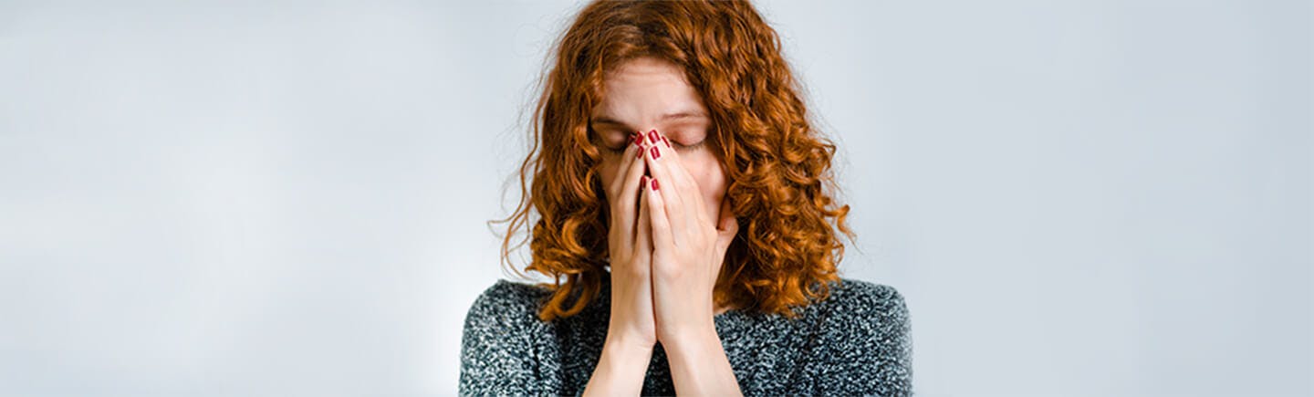 Vrouw van middelbare leeftijd snuit haar neus in verband met een verkoudheid.