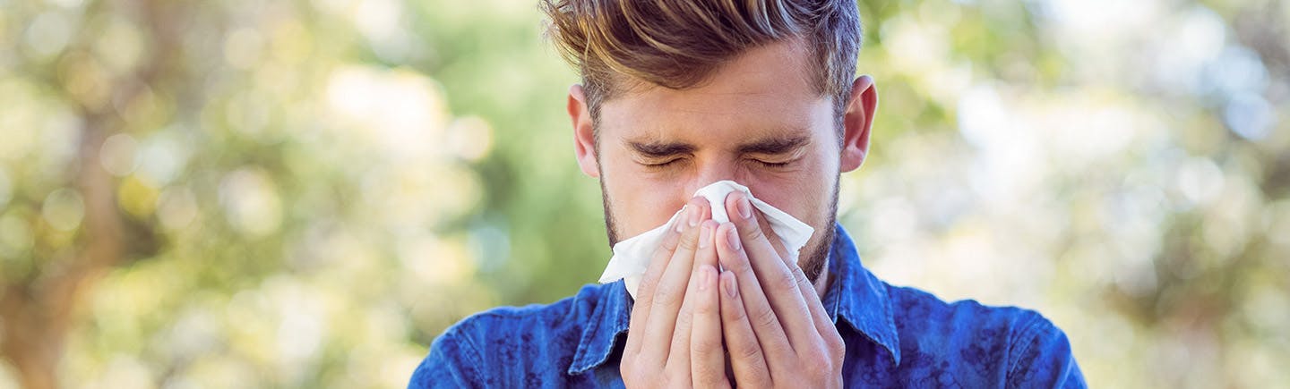 Un homme qui se mouche à cause du rhume des foins