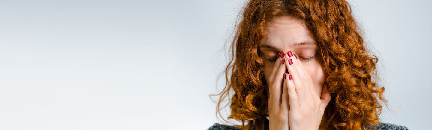 Ragazza con i capelli ricci con sintomi di rinite allergica - Rinazina