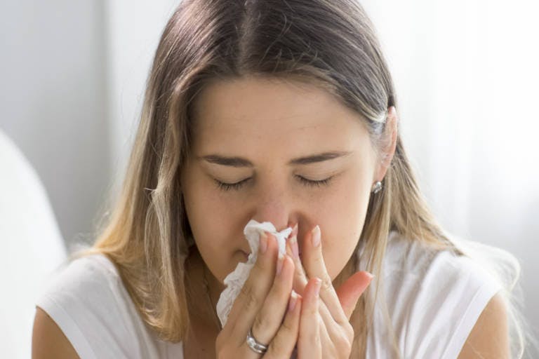 Ragazza che soffia il naso a causa della rinite da allergia - Rinazina