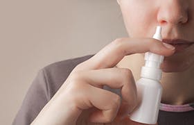 Person som er på vei til å bruke slimhinneavsvellende nesespray mot forkjølelse og tett nese fra Otrivin 