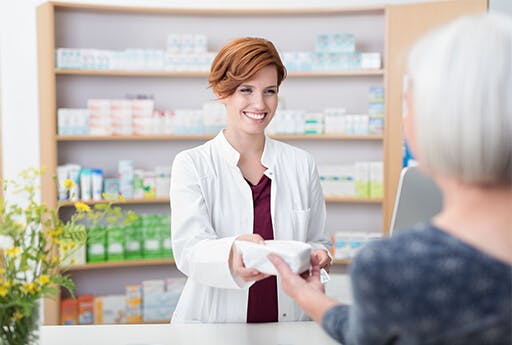Elderly female patient buys medication at the pharmacy.