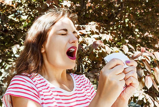 Young woman is about to sneeze because of hay fever, an allergy that can be alleviated by using Otrivin Allergy Nasal Spray.