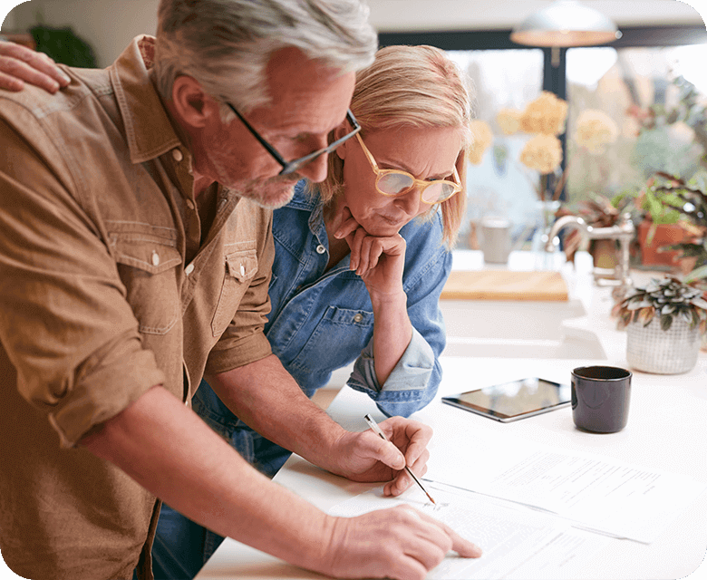 Mature couple reviewing finance documents in their home