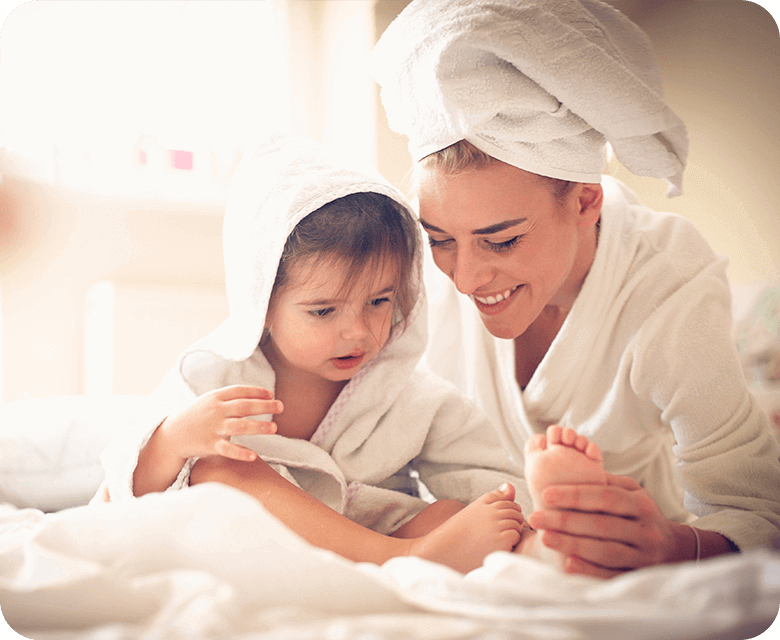 A mother and daughter wrapped in towels after a shower