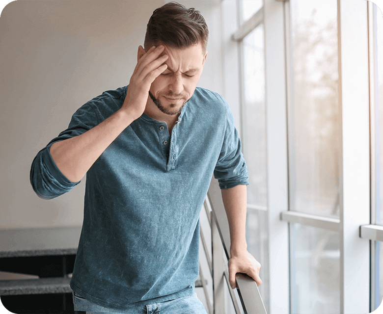 Man suffering from headache walking down stairs in office