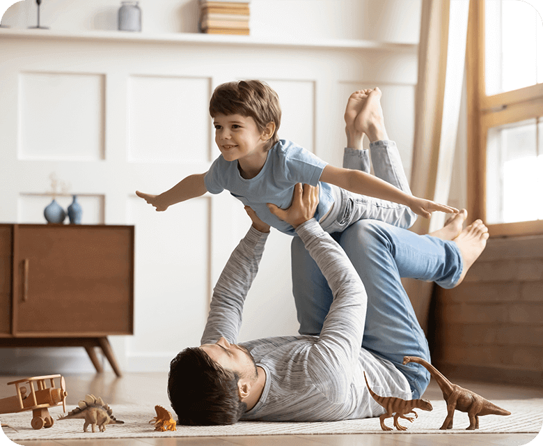 Young father playing with his daughter inside with toys
