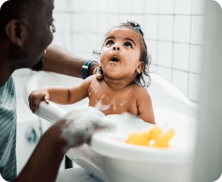Father bathing his daughter in a bathtub