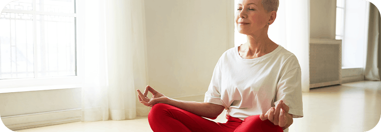 Senior woman sitting with her legs crossed performing meditation