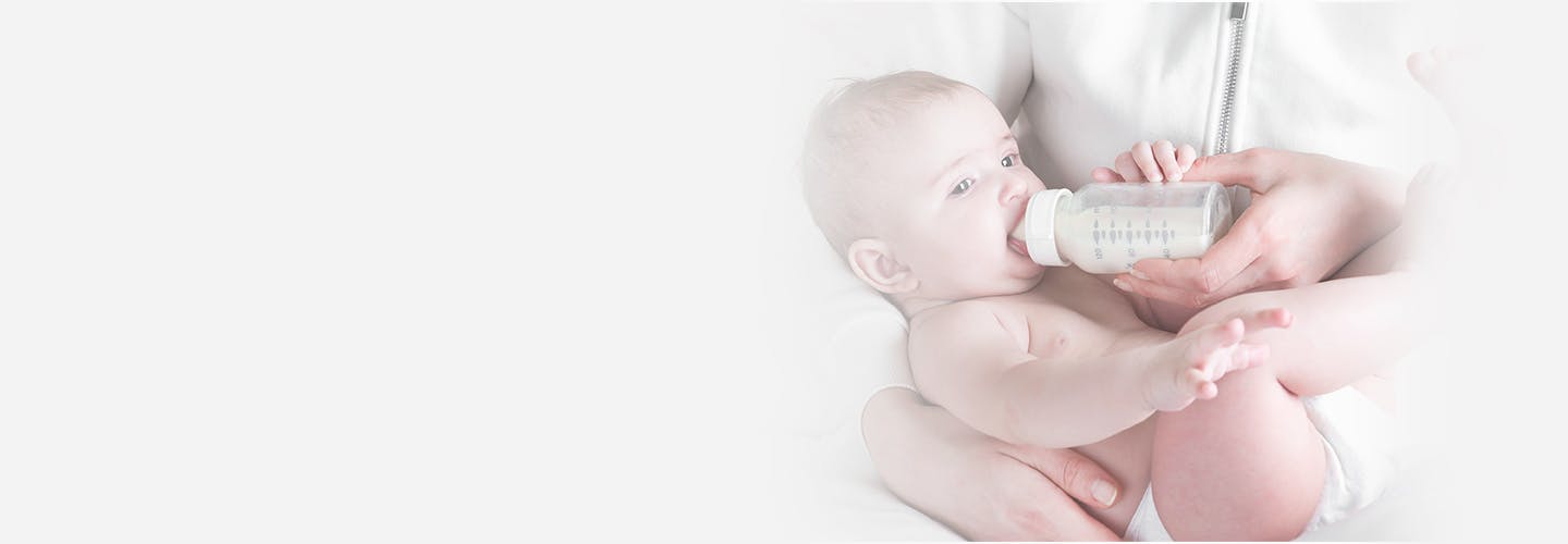 baby in diapers eating milk