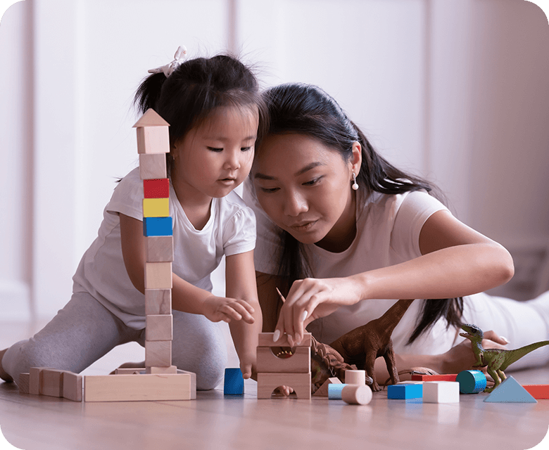 Vietnamese mother and daughter playing with wooden toys