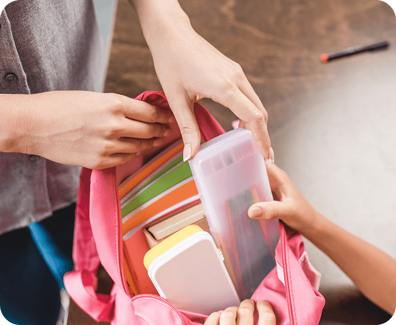 Cropped shot of mother and daughter preparing a backpack for school