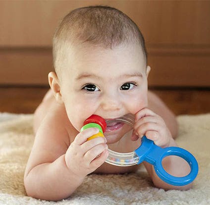 Baby biting a toy for teething. 