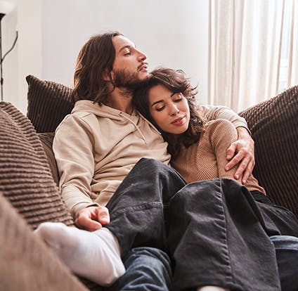 Man hugging a woman on the couch