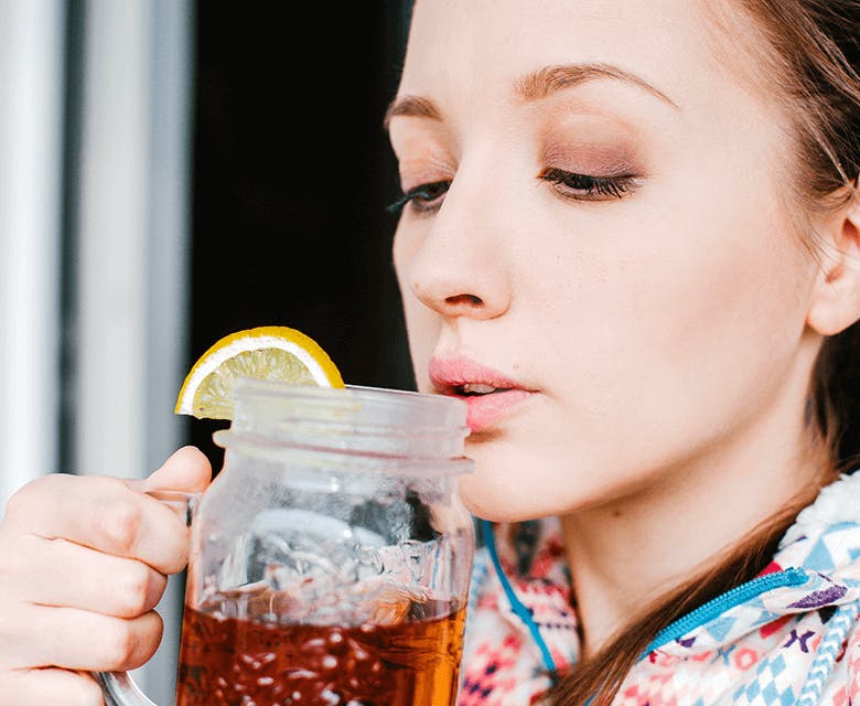 Woman drinking tea with lemon