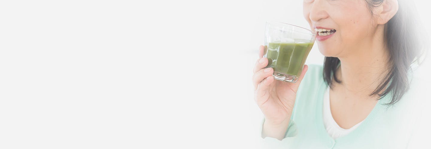 Middle aged woman drinking green juice