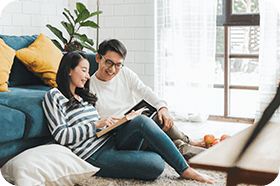 Asian couple spending time at home and reading a book