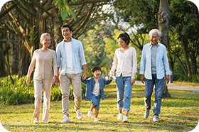 three generation happy asian family walking in park