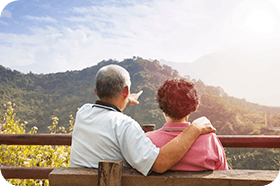 senior couple sitting on the bench looking at the nature