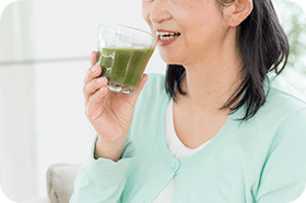 Middle aged woman drinking green juice