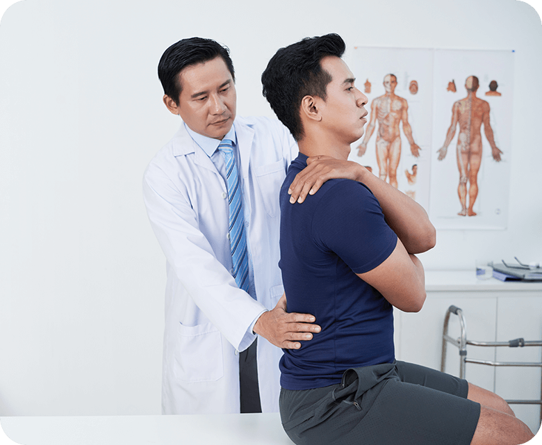 mature osteopath palpating low back patient
