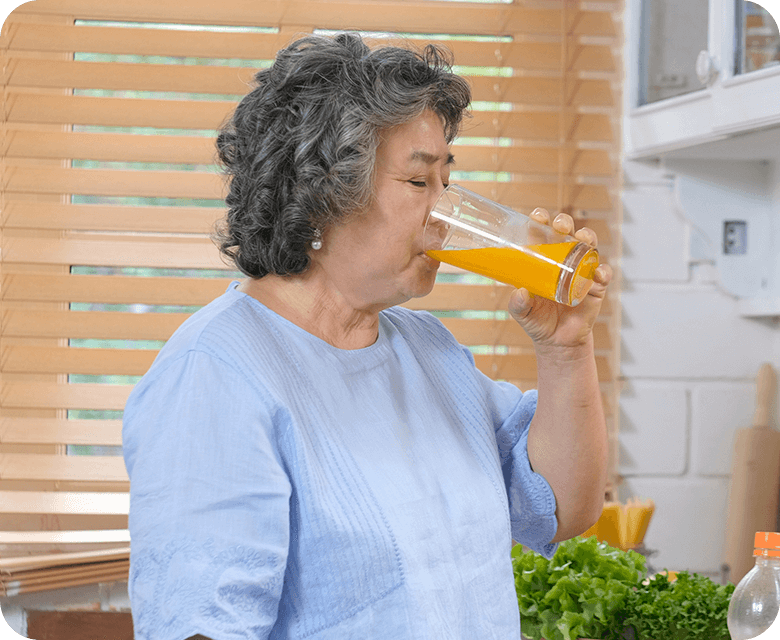 senior asian woman drinking orange juice