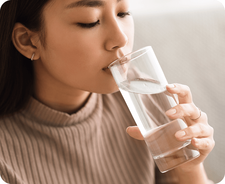 young asian woman drinking a glass of water