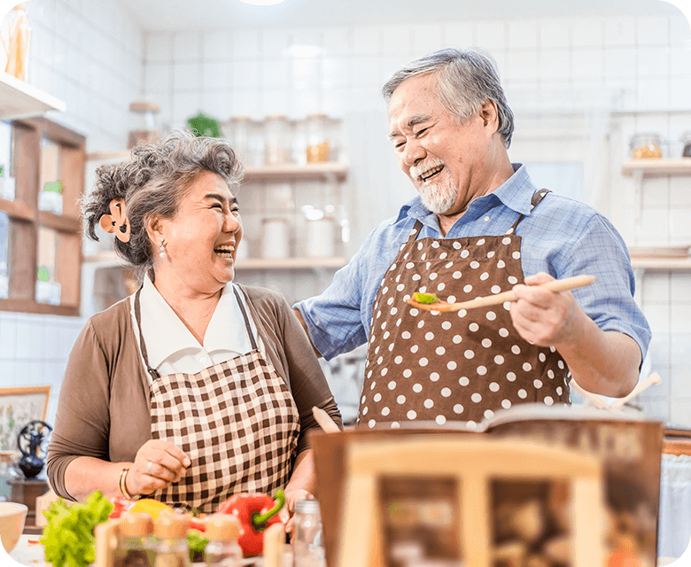 Asian senior couple cooking happily