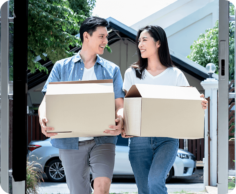 Asian couple carrying boxes and smiling
