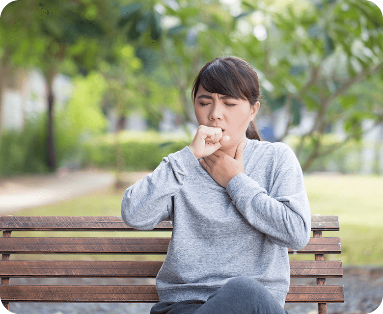 Woman coughing in the park