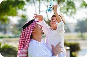 Man Holding Child While Playing