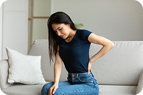 Woman On Couch With Back Pain