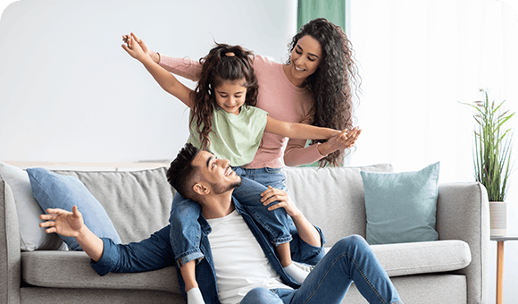 Happy Family Playing And Smiling On Couch