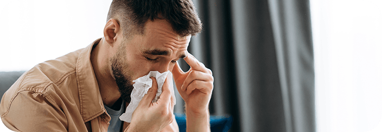 Man With Flu Symptoms Blowing Nose