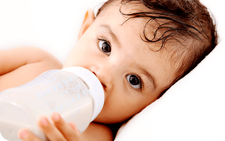 Close Up Of Baby Drinking Milk From Bottle 