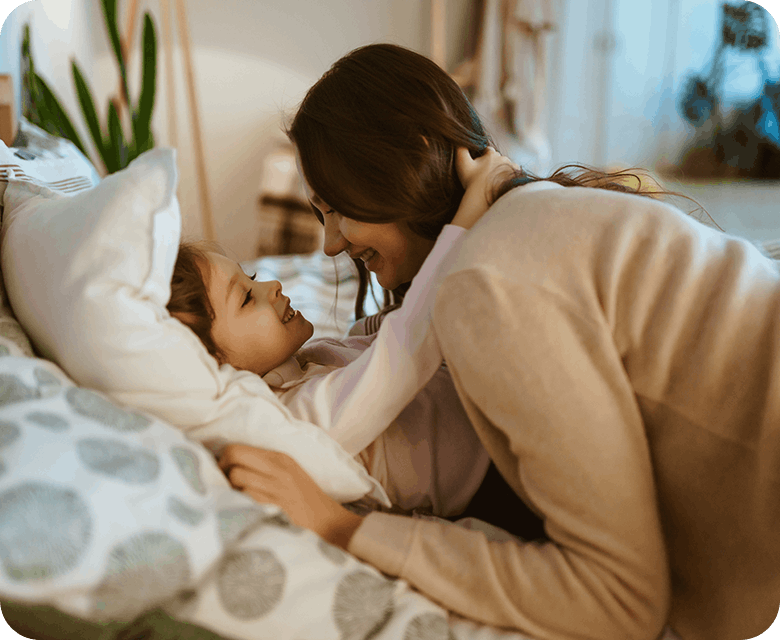 Mother Hugging Her Daughter In Bed