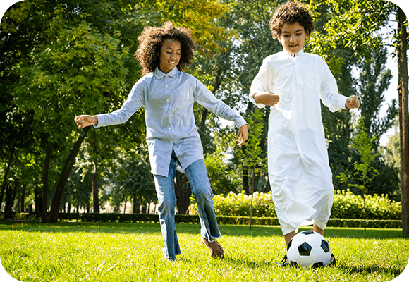 Children Playing Football On The Grass
