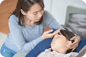 Mom checking her daughter with fever