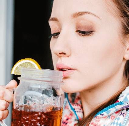 Woman drinking tea with lemon