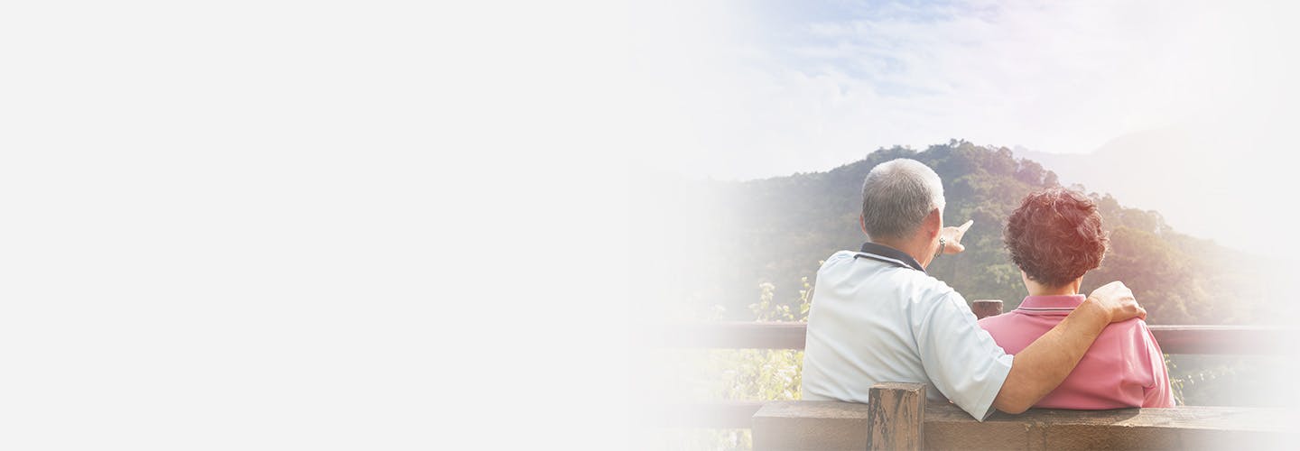 senior couple sitting on the bench looking at the nature