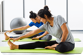 Two Asian women practicing yoga lesson together