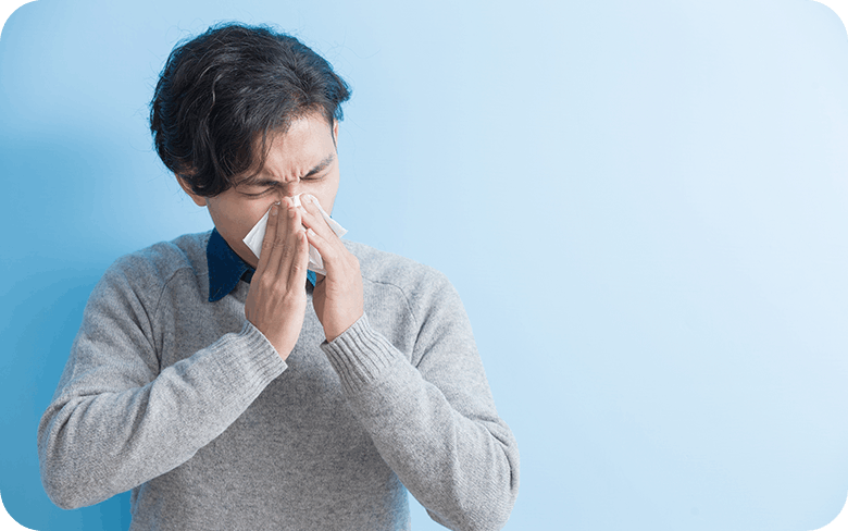 asian man blowing his nose