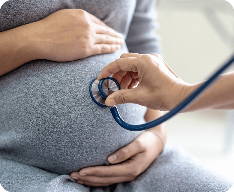 female doctor checking pregnant woman with stethoscope