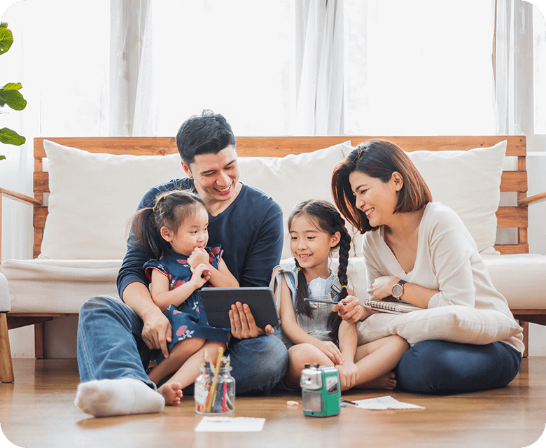 Happy Asian family watching a cartoon on the tablet in the living room