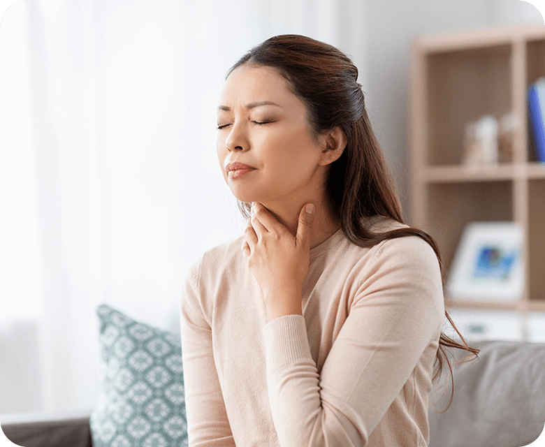 Asian woman holding her throat in pain