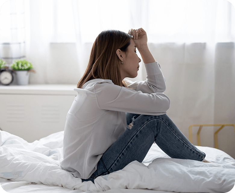 Asian woman in stress sitting on the bed