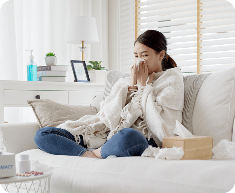 sick young asian woman sitting under blanket